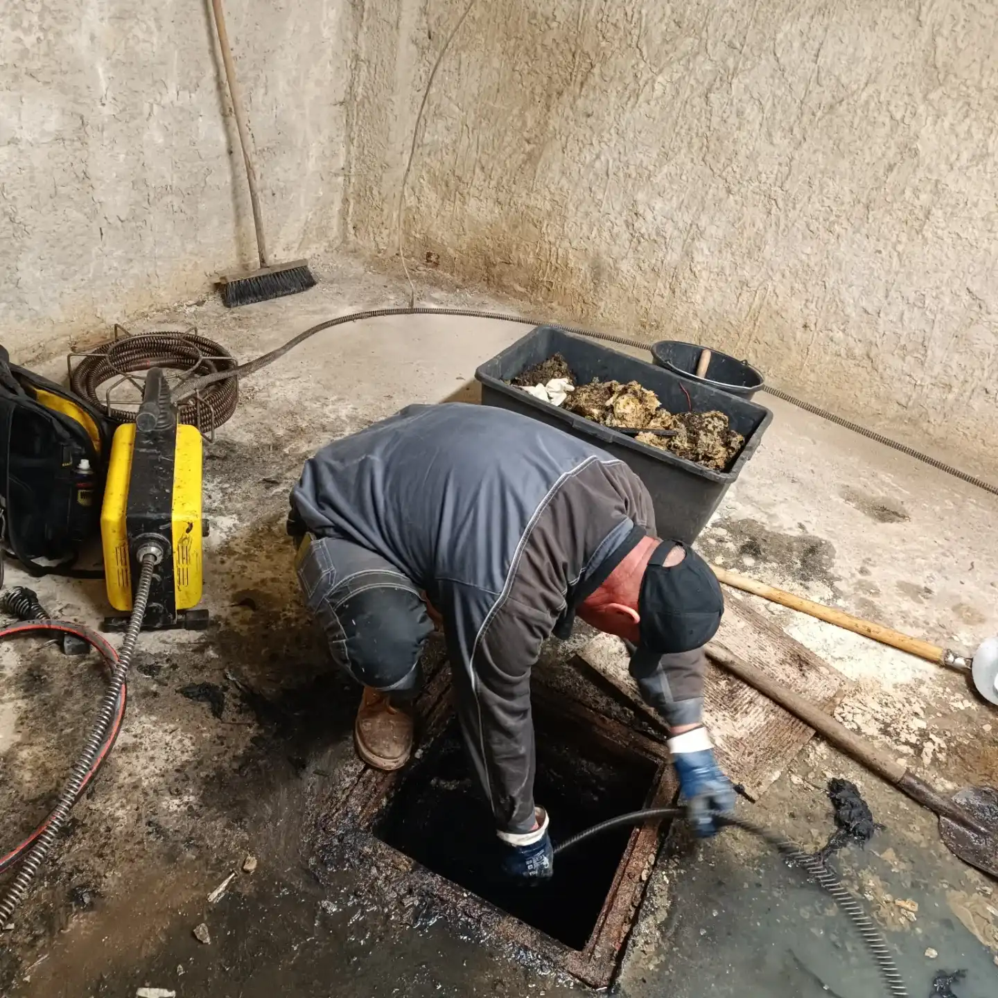 Technik havarijnej služby pri čistení kanalizačnej šachty